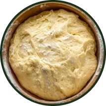 Bread dough rising in a round pan.
